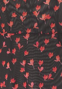 Tissu en maille noire avec un petit motif floral rose et rouge dispersé de manière uniforme sur la surface.