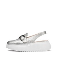 Zapato slingback plateado con parte superior texturizada, puntera redonda y tira ancha con hebilla decorativa. Suela de goma blanca.