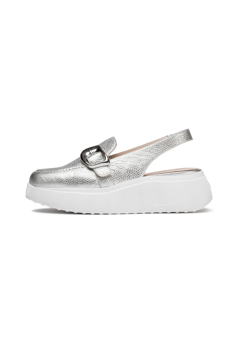 Zapato slingback plateado con parte superior texturizada, puntera redonda y tira ancha con hebilla decorativa. Suela de goma blanca.
