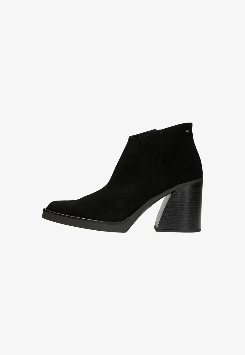 Bottine en daim noir avec un bout pointu et un talon épais texturé. Présente une silhouette élégante et des détails de couture subtils.