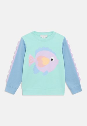 Felpa verde chiaro con maniche azzurro pastello, caratterizzata da una grande grafica di pesce in viola e rosa, con dettagli a smerlo sulle maniche.