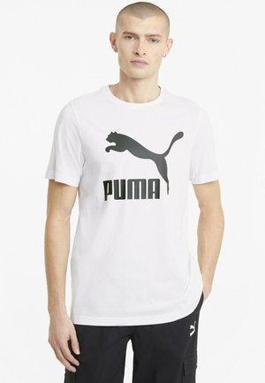 Hvid bomulds t-shirt med et stort sort Puma logo design. Kortærmet og rund hals med en afslappet pasform. Glat tekstur.