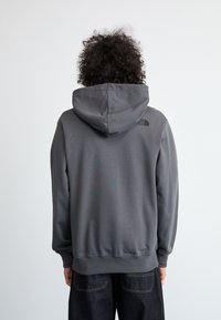 Γκρίζα ζακέτα με τσέπη καγκουρό, ριμπ μανσέτες και στρίφωμα. Διαθέτει λογότυπο στην πλάτη, φτιαγμένη από μαλακό, αναπνεύσιμο ύφασμα.