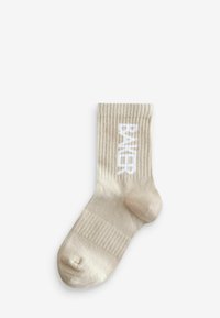 Beige gerippte Socke mit einem weißen "BAKER"-Logo. Das Material scheint weich mit einer glatten Textur zu sein und hat ein rundes Zehendesign.