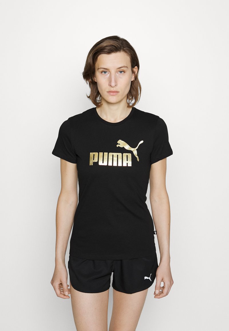 Black t-shirt made of cotton with a gold "PUMA" logo and leaping puma graphic. Paired with black shorts featuring a small white logo.