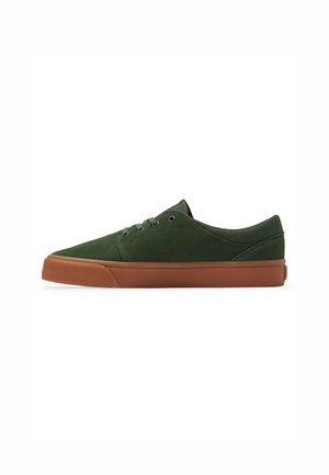 Zapato casual de ante verde con un diseño de caña baja, que presenta una suela de goma color marrón, seis ojetes y una puntera redondeada.