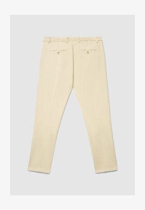 Pantalon beige à texture lisse, doté d'une ceinture élastique, de deux poches arrière avec boutons, et d'une coupe fuselée.