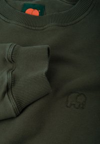 Sudadera verde oscuro con cuello y puños acanalados, que presenta un pequeño logotipo de elefante bordado. Textura de tela suave.