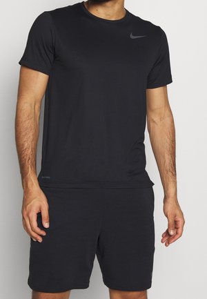 Camiseta atlética negra hecha de un tejido ligero. Mangas cortas, cuello redondo, con un sutil logo de Nike en el pecho.