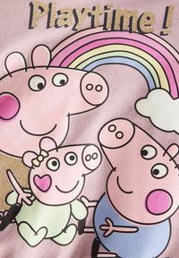 Kolm joonistatud siga naeratavad vikerkaare all, mille kohal on sädelev tekst "Mänguaeg!" roosa taustal.