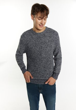 Sweter z okrągłym dekoltem, dzianinowy w kolorze granatowym, z teksturowanym, melanzowym wzorem. Długie rękawy i odprasowane mankiety dopełniają casualowy design. Połączony z dżinsami.