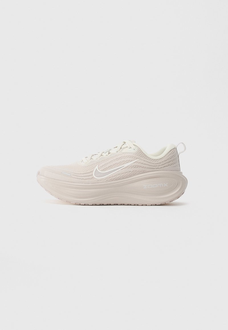 Beżowe buty do biegania Nike ZoomX z grubą, wysoce amortyzującą podeszwą oraz białym logo Swoosh na jednolitym białym tle.