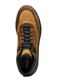 Zapato de ante y cuero marrón con cordones negros y suela de goma texturizada negra. Presenta una puntera redonda y un cuello acolchado para mayor comodidad.
