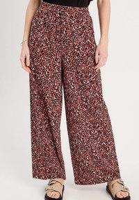 Pantalons larges avec un imprimé léopard rose et noir. Dotés d'une taille élastique et d'une texture de tissu lisse. Accentués par un design fluide.