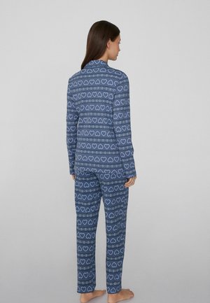 Dwuczęściowe piżamy z miękkiej, elastycznej tkaniny, z niebieskim tłem w serca i płatki śniegu. Długie rękawy i spodnie z luźnym krojem.
