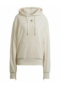 Kremfärgad huvtröja av mjukt tyg med kanguruficka, huva med dragsko och gulddetalj med logotyp på bröstet. Har unika blixtlås på sidorna.