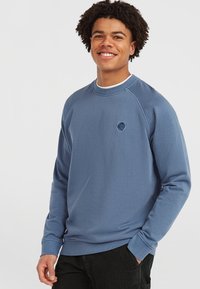 Blå bomulds sweatshirts med rund hals, ribstrikkede manchetter og et lille logo på brystet. Glat tekstur og afslappet pasform.