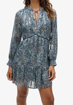 Blue patterned dress featuring a paisley design, long sleeves, gathered cuffs, tie neckline, and a tiered, flared hemline.