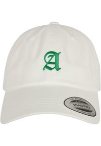 Hvit baseballcaps med et grønt brodert bokstav "A" på fronten. Har en buet skjerm og en justerbar stropp bak.