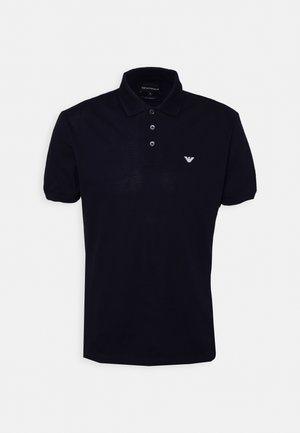 Marineblaues Poloshirt aus Baumwolle mit einer dreiknöpfigen Knopfleiste, kurzen Ärmeln und einem kleinen weißen Logo auf der linken Brust.