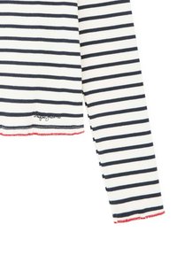 Top de manga larga a rayas blancas y navy, con textura acanalada, que presenta un dobladillo ondulado con costuras rojas y un pequeño logo de la marca.