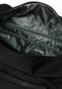 Borsa di stoffa nera con una cerniera aperta che rivela un rivestimento interno scuro e una tasca interna con cerniera con etichetta logo Napapijri.