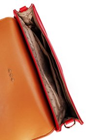 Rote Lederhandtasche mit einem hellbraunen Innenfutter. Verfügt über mehrere Reißverschlussfächer und ein gepunktetes Futter. Metallische Hardware-Details mit einer seitlichen Schlaufe.