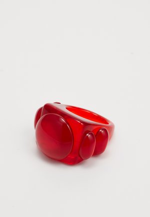 Red resin ring featuring rounded, bubble-like shapes and a smooth, glossy finish. The design includes varying sizes of spheres.