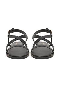 Czarne płaskie sandały z wieloma skrzyżowanymi paskami, wykonane z gładkiej skóry, z zapięciem na klamrę oraz subtelnym przeszyciem wzdłuż podeszwy.