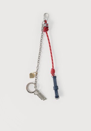 Porte-clés avec une chaîne en argent, un cordon rouge noué, une sangle en cuir bleu, un pendentif en forme de cœur en métal et des breloques avec le logo Tommy Jeans.