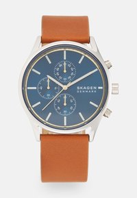 Orologio cronografo con quadrante blu navale, cassa argento, dettagli dorati e cinturino in pelle marrone con texture liscia.