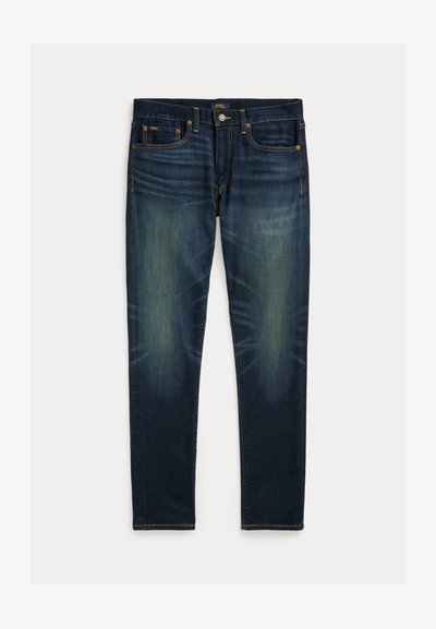 Blugi slim fit bleumarin cu detalii estompate, design cu cinci buzunare și închidere cu nasturi, așezați pe o suprafață plană, pe fundal alb.