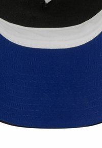 Blau und schwarze Mütze mit einem schwarzen Oberteil, weißem Streifen, blauer Schirm und strukturiertem Stoff. Das Design umfasst Nähdetails und einen gebogenen Schirm.