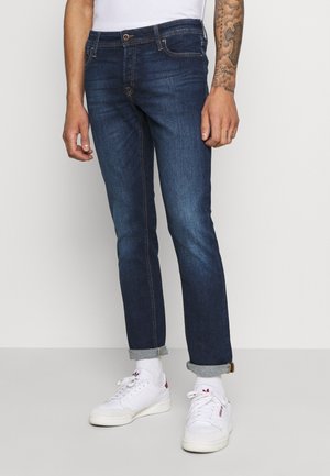 Jeans en denim bleu foncé avec une coupe slim, dotés d'un design classique à cinq poches, de bas de pantalon retroussés et d'une ceinture cousue.
