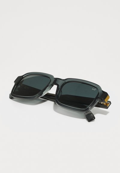 Square sunglasses with dark lenses, gray acetate frame, detailed temples, and gold accents. Lenses have a dark tint for UV protection.