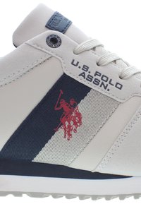 Bílé tenisky s námořnickými akcenty, texturovaný materiál, s červeným logem póla a označením "U.S. POLO ASSN" na boku.