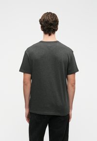 Grå bomulls kortermet T-skjorte med rund hals og løs passform. Jevn tekstur uten mønstre eller detaljer.