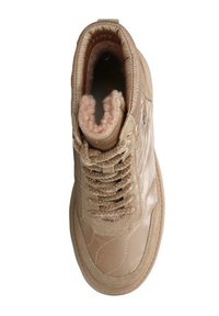 Baskets montantes beiges avec une surface extérieure en cuir lisse et brillante, une doublure moelleuse et des lacets texturés en croix. Détails de coutures discrètes.