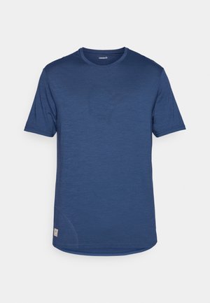 Lühikeste varrukatega sinine sporditasemel T-särk, millel on sile tekstuur, ümmargune kaelus ja diskreetne logo detail vasakul ees.