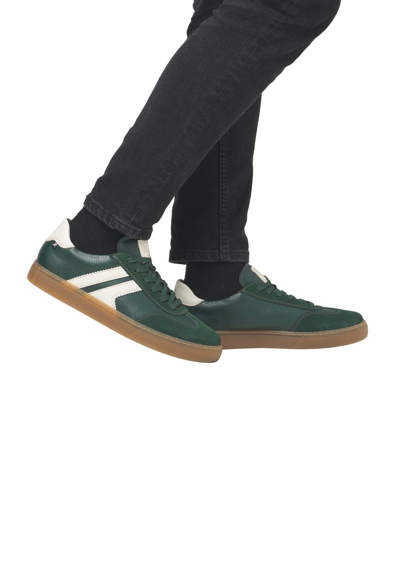 Gröna och vita sneakers med en texturerad ovandel, gummisula och rund tå. Har snörningsdesign och kontrasterande sidostreck.