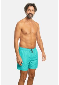 Bañador en color turquesa con cintura elástica y cordón ajustable. La tela parece suave y tiene un diseño ligero, adecuado para actividades acuáticas.