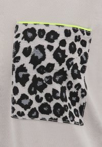 Tejido gris con un bolsillo de estampado de leopardo negro que presenta una textura brillante y un ribete verde neón a lo largo del borde superior.