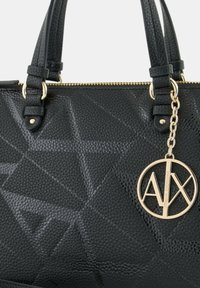 Borsa a tracolla nera con texture e motivi geometrici, hardware dorato e charms con logo. Presenta manici doppi e chiusura con zip.