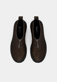 Brown vegan leather ankle boots with a side zipper, rounded toe, textured finish, and a black rubber sole. Two pull loops at the back.