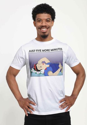 T-shirt en coton blanc arborant un graphisme cartoon d'une figure endormie avec des cheveux bruns et des accents rouges, avec la légende "JUSTE CINQ MINUTES DE PLUS."