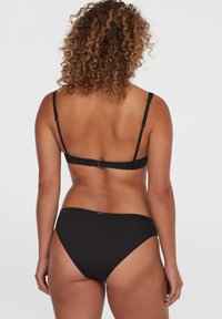 Set di bikini nero con spalline regolabili e taglio classico. Tessuto liscio con dettagli minimi. La vista posteriore mostra un design senza cuciture.