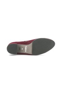 Chaussure en suede bordeaux avec une semelle en caoutchouc, forme effilée, et un détail zip sur le côté. Nom de la marque "Gabor" imprimé sur la semelle intérieure.