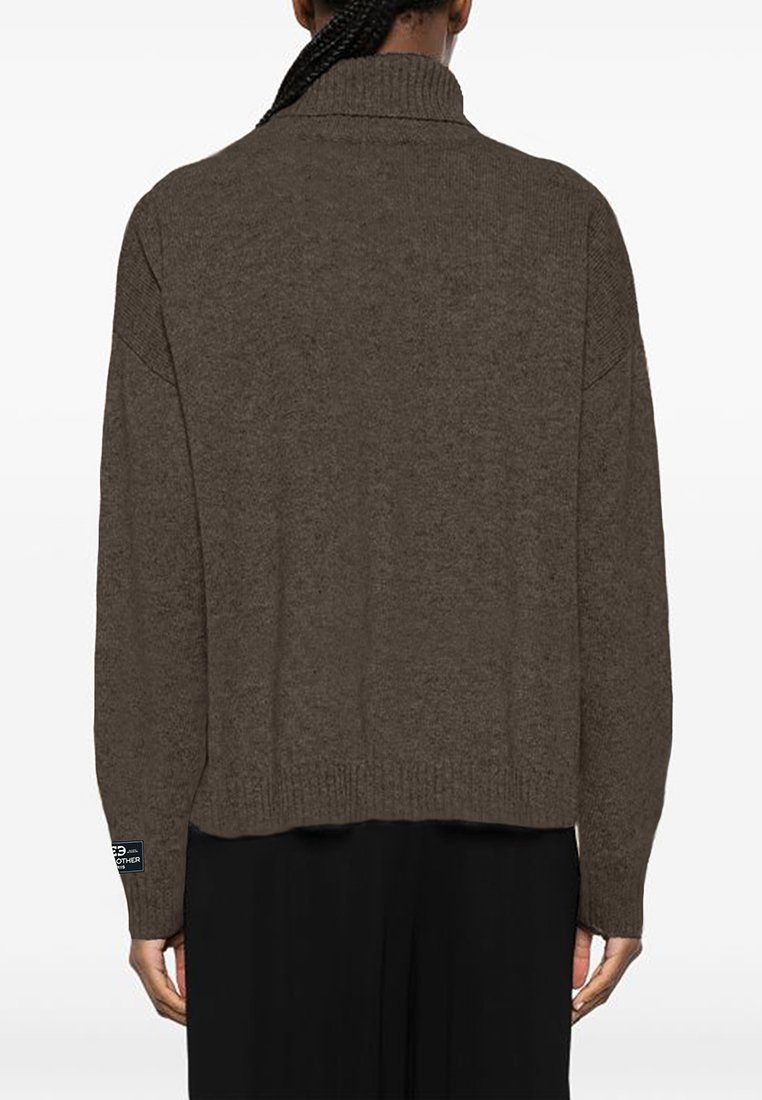 Brązowy sweter dziergany z wysokim kołnierzem, opuszczonymi ramionami i prążkowanym dołem. Posiada naszywkę z logo na rękawie. Prosta, teksturowana powierzchnia.