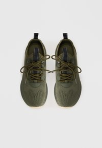 Baskets de sport vert olive avec une tige en maille texturée, des accents noirs contrastants, des lacets ronds et une semelle en caoutchouc. Vue de dessus.