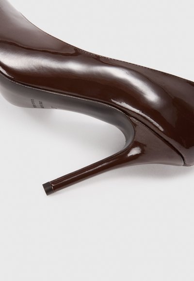Smeđa cipele od lakirane kože s visokom potpeticom, elegantnog dizajna, šiljatog vrha, glatke teksture i tanke stikle.